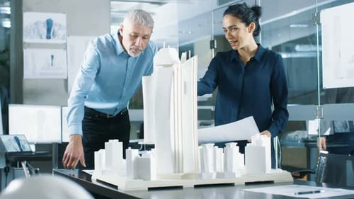 In the Architectural Bureau Two Engineers Work on a Model of a City District. Urban Planners Work o