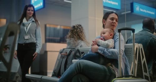 Airport Terminal Adult Woman Sitting with Infant and Waiting for Airplane Flight
