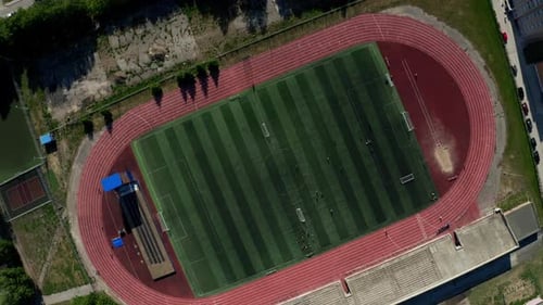 A Green Football Field with a Running Track A Sports Stadium Shot From a High Altitude