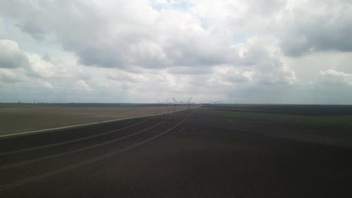 Aerial View of Power Lines Over Green Agricultural Field