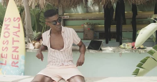 Young Adult Relaxing at Tropical Beachside Bar