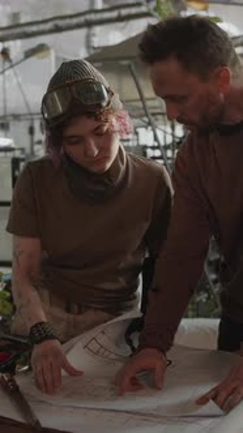 Homem e mulher discutindo plantas em um abrigo pós-apocalíptico