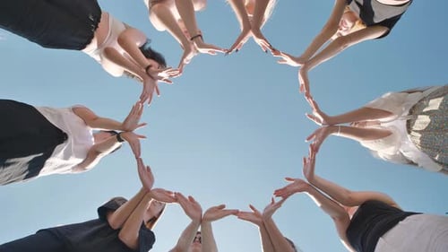 Gruppe von Freunden, die mit zusammenliegenden Händen eine Sternform formen