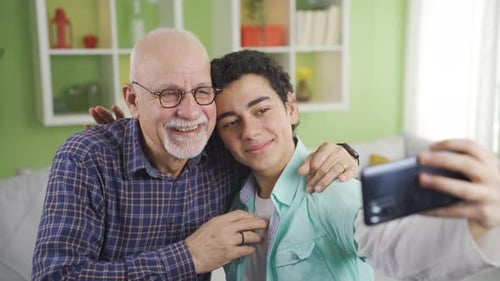 Teen and Senior Smiling Together Taking Selfies Indoors