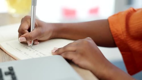 Close Up of Hands Writing in Notebook