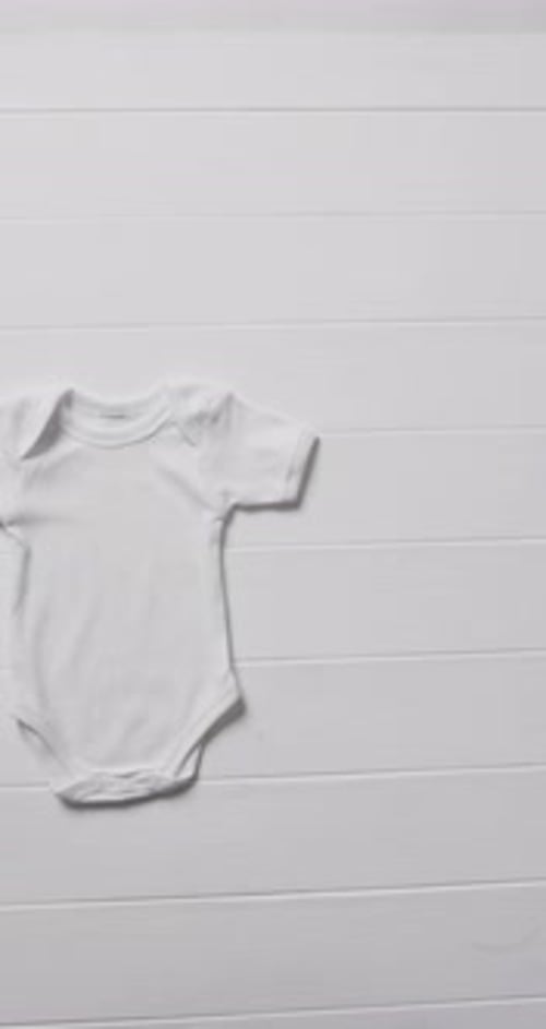 Vertical video of white baby grow with copy space on white background
