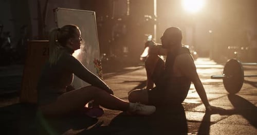 Woman and Man Resting in Gym