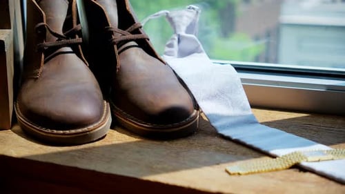 Brown Leather Boots, Tie and Watch on Window