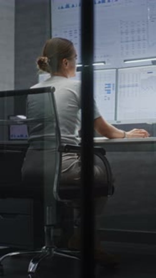 Female Stock Broker Monitoring Exchange Market Charts on MultiMonitor Desktop Setup in Office