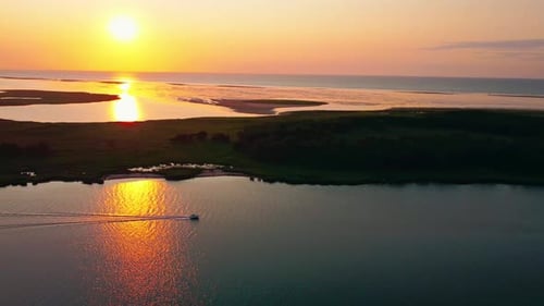 Sunset at the sea, an island in the background, calm water, perfect evening, boat driving across the