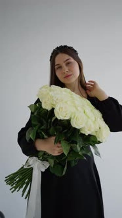 Woman Holds White Rose Bouquet in a Black Dress