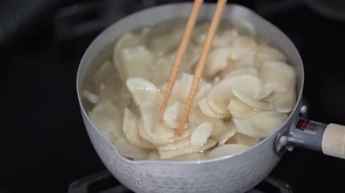 Sliced Food Cooking in Pot on Stove
