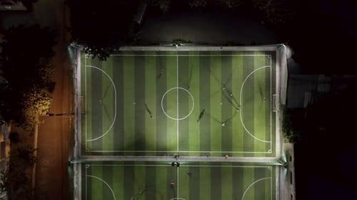Aerial view of Football Team Practicing at Night on Soccer Field