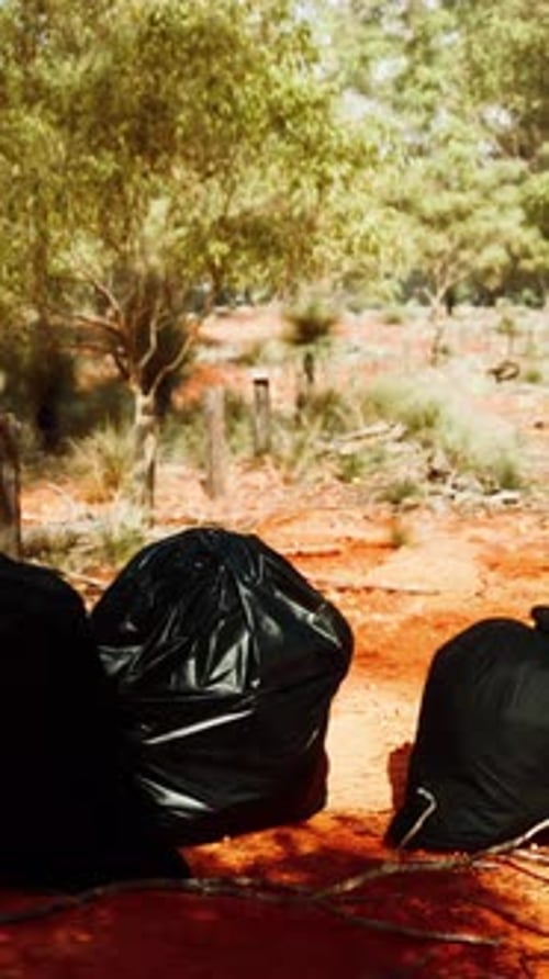 Closeup of Full Trash Bags on the Sand