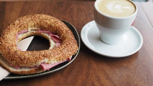 Bagel Sandwich and Cappuccino on a Wooden Table