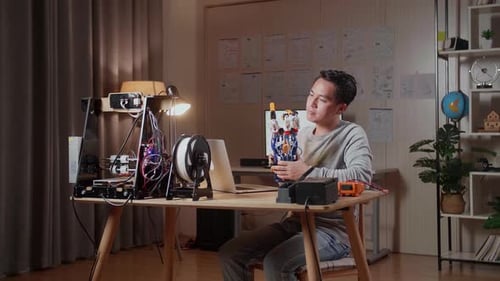 Man Assembles Robotic Hand at Desk
