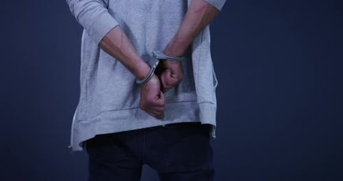 Hands, cuffs and closeup of man criminal in studio for illegal crime, danger or corruption