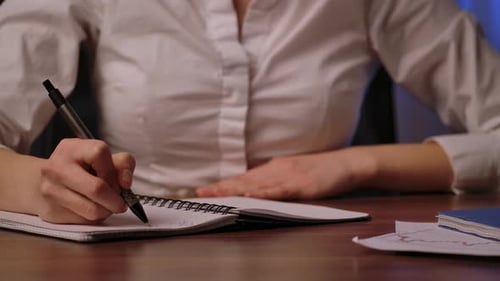 Close Up of Woman Writing Notes in Notebook