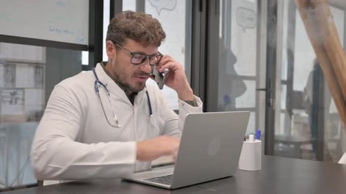 Male Doctor Talking on Phone in Clinic