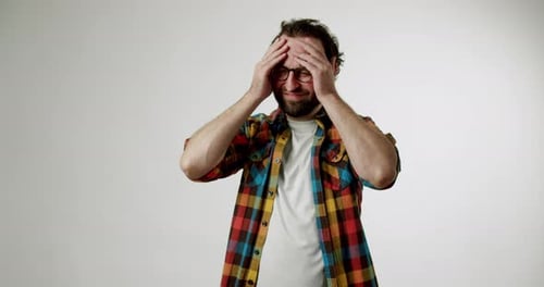 Bearded Man Suffering Headache in Studio Setting