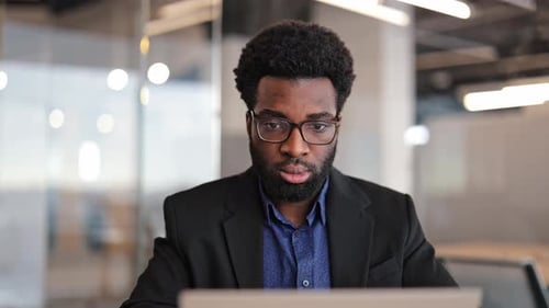 Businessman Working on Laptop in Modern Office