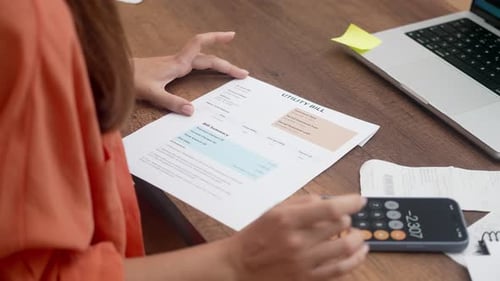 Lady Manages Household Utility Bills Online Clutching Payment Receipts for a Seamless Transaction