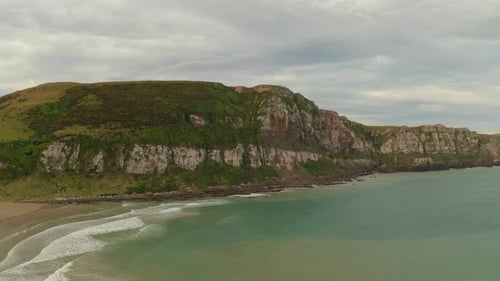 Slow aerial sliding right to left shot of cliffs along the coastline in New Zealand