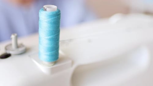 Close Up Turquoise Thread on Sewing Machine Spool