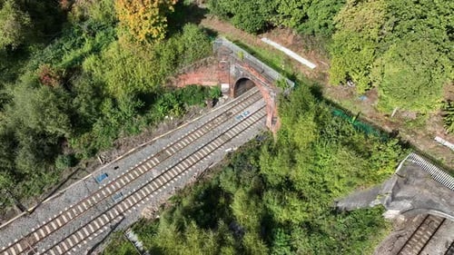 Commuter Train Exiting a Tunnel at High Speed Aerial View