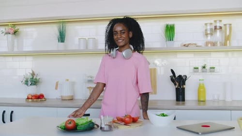 Smiling Woman in Kitchen with Headphones