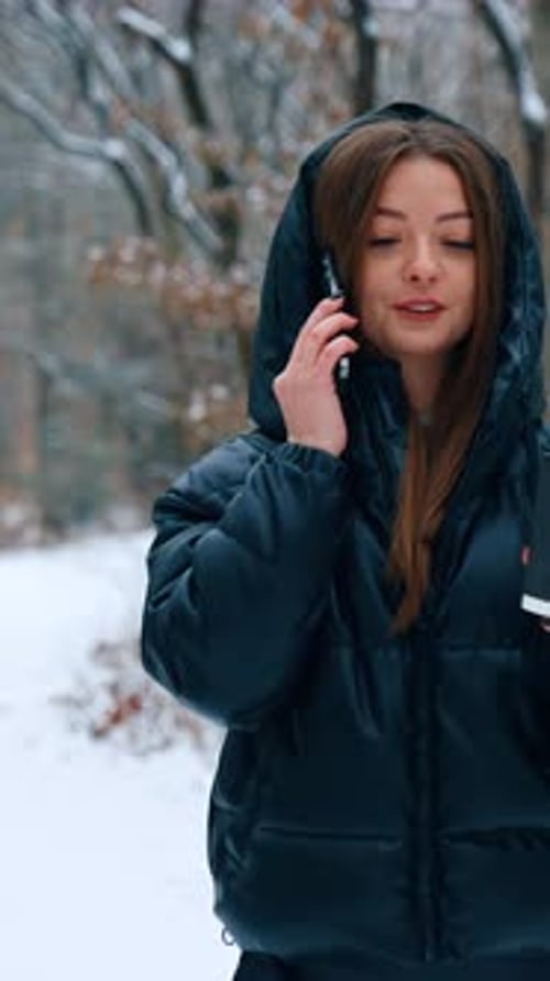 Woman Talks on Phone Holding Coffee in Winter
