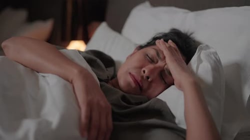 Woman Sleeping in Bed with a Headache