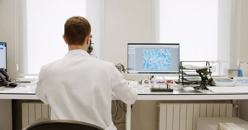 Scientist Working with Microscope in Bright Laboratory