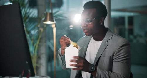 Black man, fast food and eating in office at night for work, overtime and project deadline