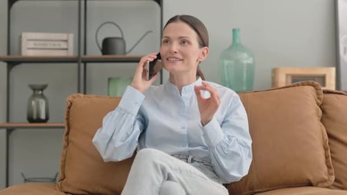 Woman Conversing on Cellphone While Sitting on Couch