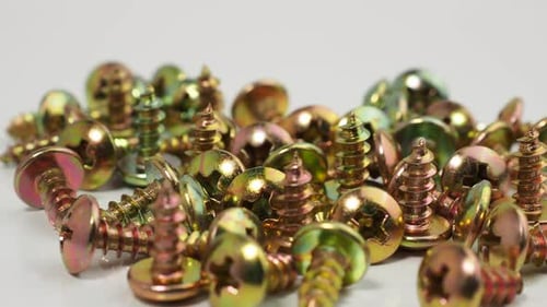 Metal screws on a white background. Rotating screws for driving into plastic.