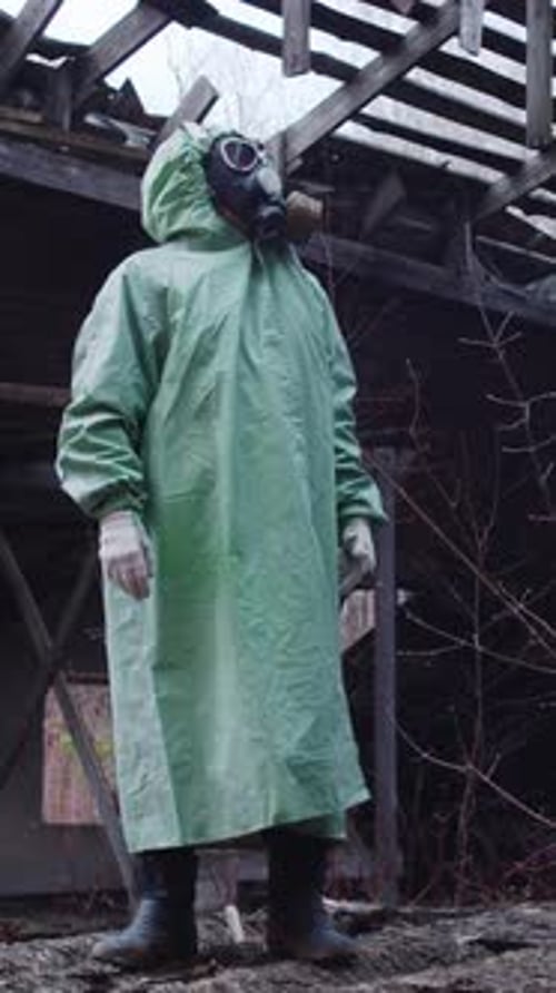 A Man in a Protective Suit and a Gas Mask