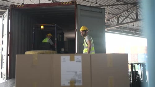 Blue collar workers are working at warehouse.