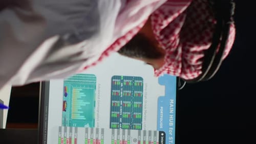 Man Reviews Stock Data in Office Setting