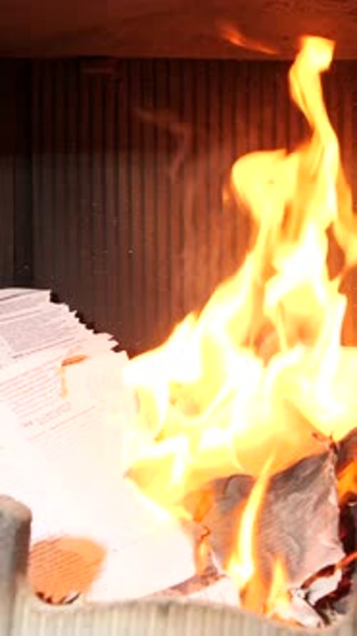 Vertical Video Flickering Flames Consuming Papers in a Cozy Fireplace