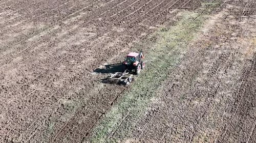 Tractor Tilling Field on a Farm, Aerial View