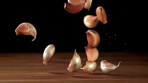 Garlic Falls on a Wooden Table Filmed on a Highspeed Camera at 1000 Fps