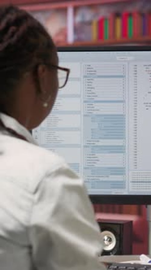 Woman Coding and Reviewing Software on Computer Monitor
