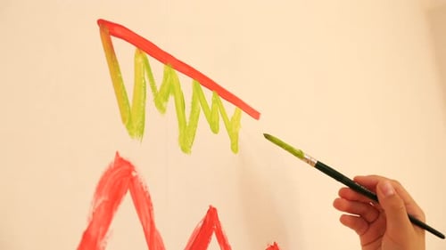 Artist Painting Green Zigzag Lines on White Wall with Brush