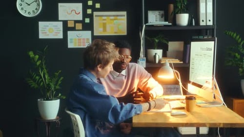 Young Colleagues Discussing Financial Presentation in Modern Office