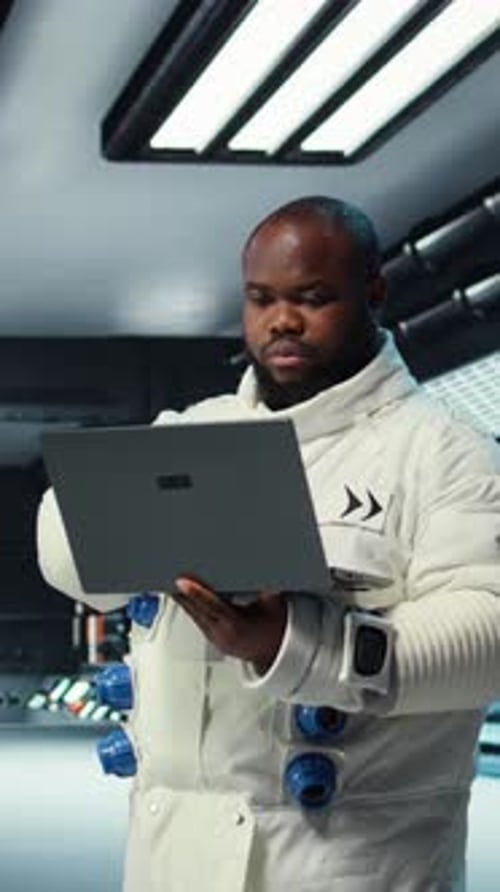 Vertical Video Astronaut Crew Inside Futuristic Spacecraft Monitoring Mission Data on Laptop