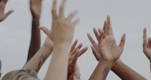 Diverse Group Raising Arms in the Air Together