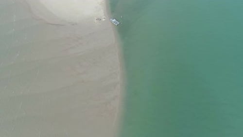 Boat lying on the beach aerial view. Young beautiful yacht resting on white sand beach top view. Aer
