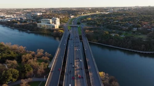 Aerial shot of busy traffic on highway bridge with cars commuting and traveling. Drone view