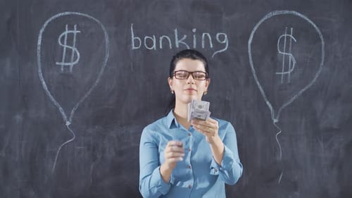 The woman who writes Banking on the blackboard looks up with a sad expression.